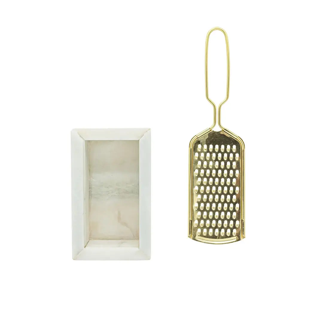 Gold grater next to a white rectangular container on a white background