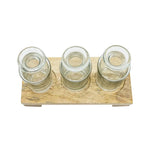 Three glass jars on a wooden tray with a white background