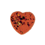 Heart-shaped orange bath bomb with floral petals on a white background
