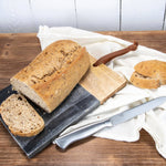 Loaf of bread with a knife on a wooden surface