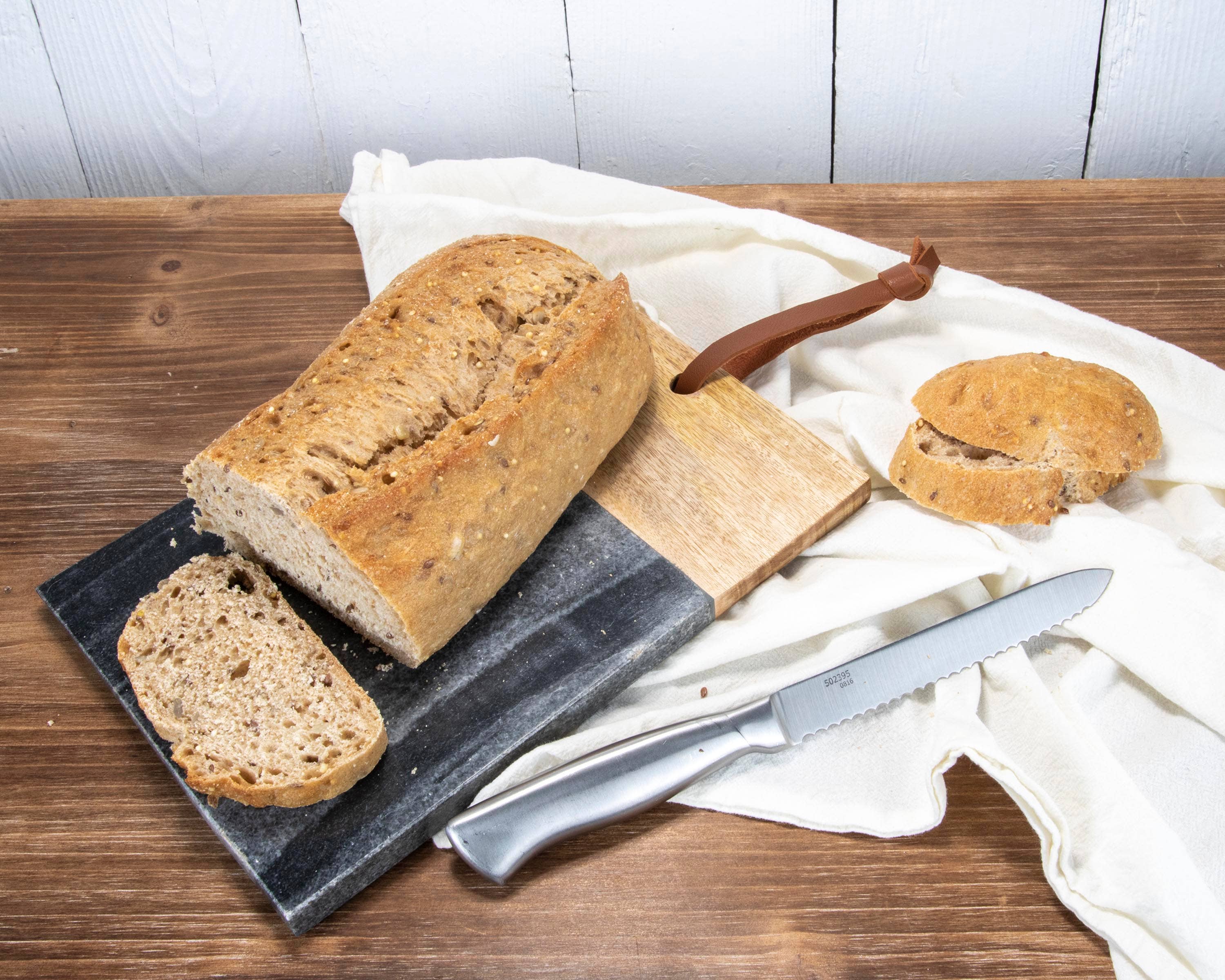 Loaf of bread with a knife on a wooden surface