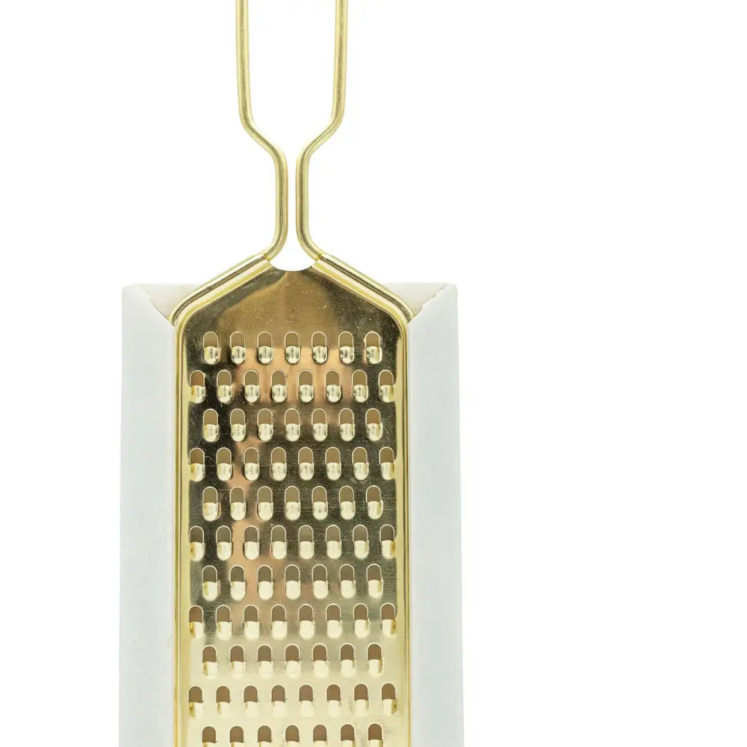 Rectangular grater with gold metal surface on a white background