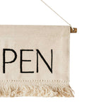 Textile banner with 'OPEN' printed on it, hanging against a white background