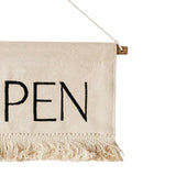 Textile banner with 'OPEN' printed on it, hanging against a white background