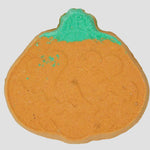 Pumpkin-shaped bath bomb with green top on a white background