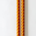 Two twisted orange sticks on a white background