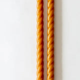 Two twisted orange sticks on a white background