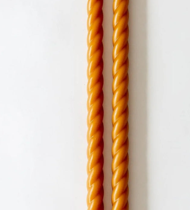 Two twisted orange sticks on a white background