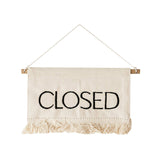 Fabric sign with 'CLOSED' text hanging on a white background
