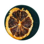Dried orange slice on a black round surface