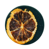Dried orange slice on a black round surface