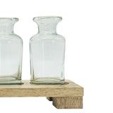 Two clear glass vases on a wooden stand against a white background